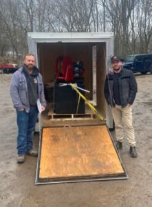 Adam from pavement depot and customer standing beside his new pro 200 asphalt sealing unit that is in his trailer