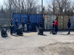 How to crack fill in asphalt training day at pavement depot, customers standing around a RynoWorx crack filling machine getting free training