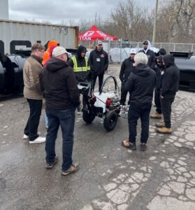 How to line paint training day at pavement depot, customers standing around a Titan 3500 line striping machine getting free training