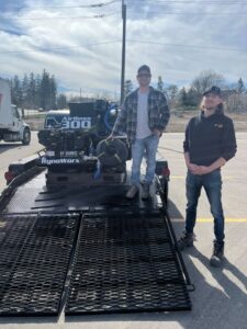 Customer gathered around their new RynoWorx Airboss 300 Asphalt Sealing Machine at Pavement Depot